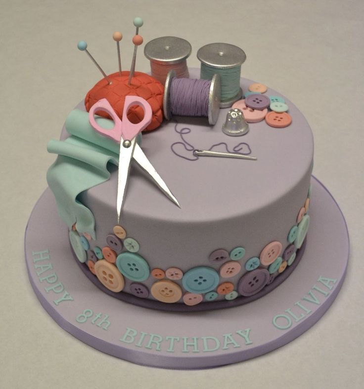 a birthday cake decorated with buttons and scissors