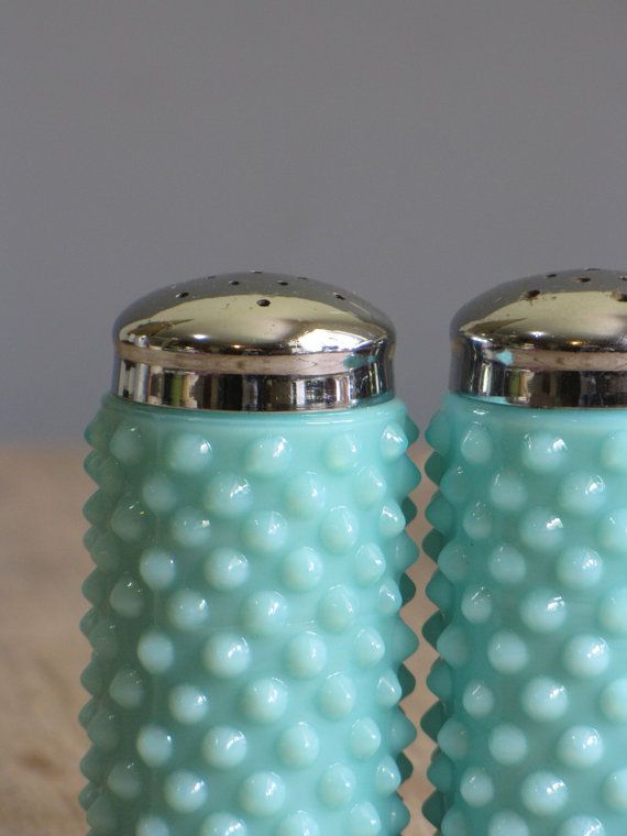 two blue salt and pepper shakers sitting on top of a table