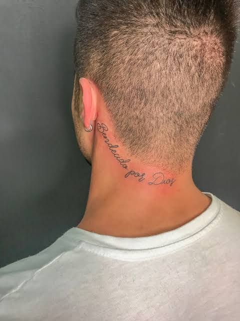 the back of a man's head with a tattoo on his left side neck