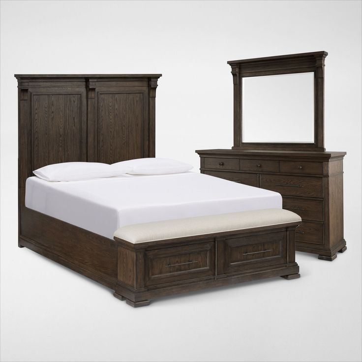 a bed, dresser and mirror are shown in this image with white sheets on it