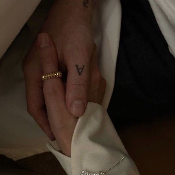 a man and woman holding each other's hands with their wedding rings on them