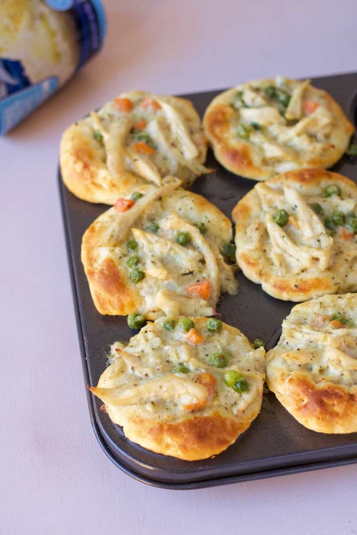 some food that is sitting on a black tray and ready to be cooked in the oven