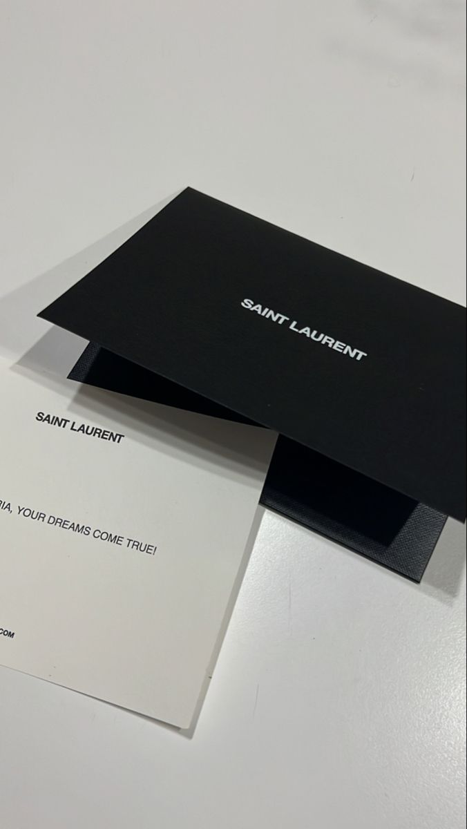 two black and white business cards sitting on top of each other next to one another