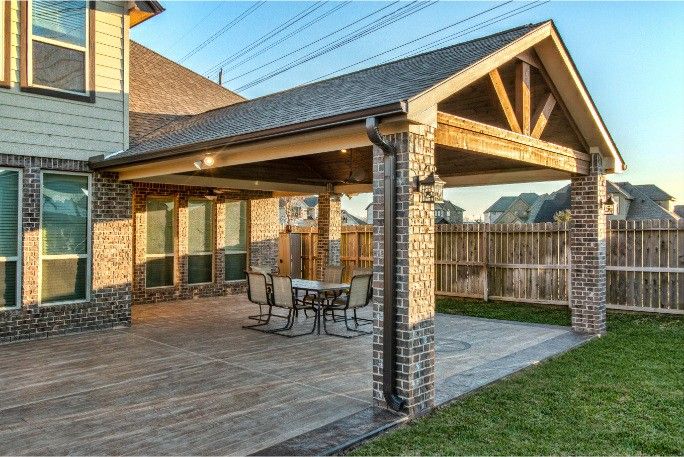 a covered patio with table and chairs on it