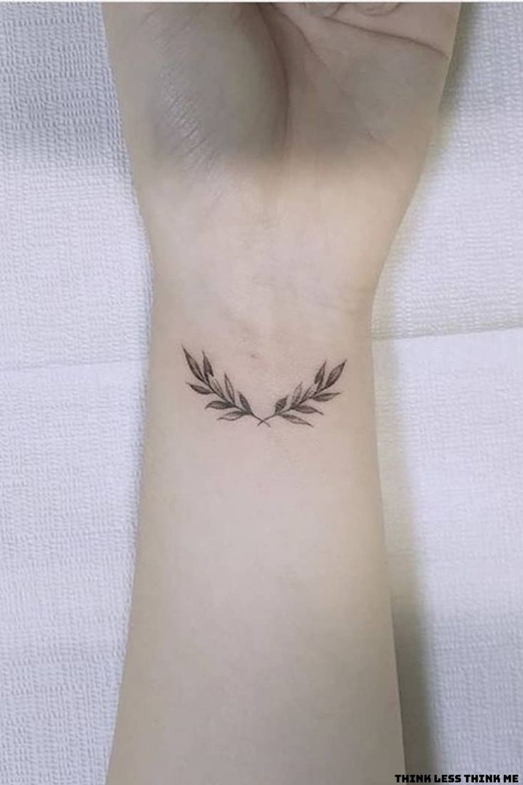 a woman's wrist tattoo with two leaves on it