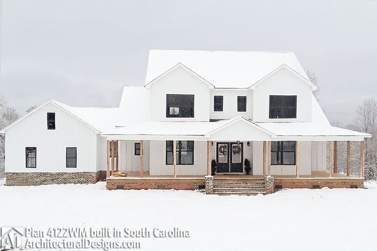 a large white house sitting on top of a snow covered field