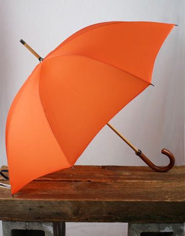 an orange umbrella sitting on top of a wooden table