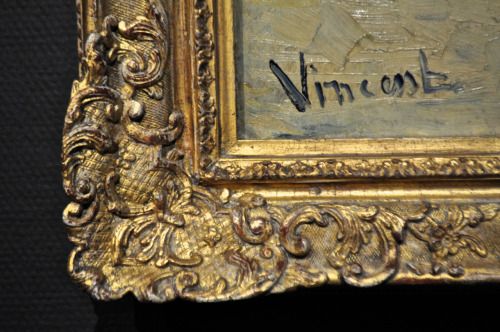 an ornate gold frame with the word wincom written in cursive writing on it