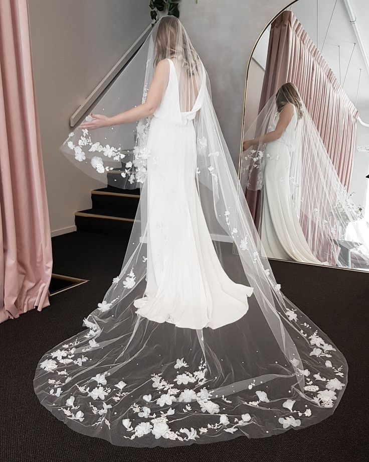 the bride is getting ready to walk down the stairs in her wedding dress and veil