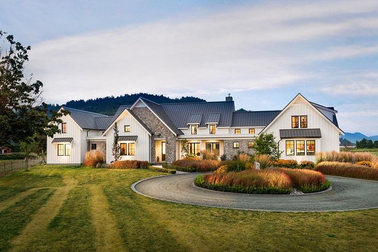 a large white house sitting on top of a lush green field