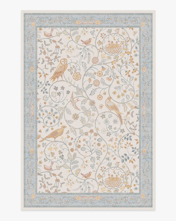 a white and blue rug with birds on the border, surrounded by floral vines and leaves