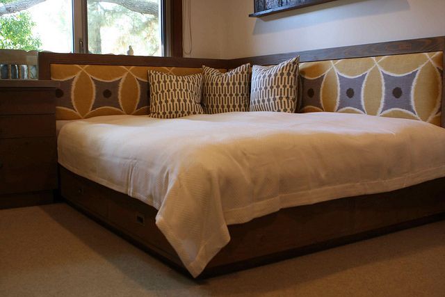 a large bed sitting in a bedroom next to a window