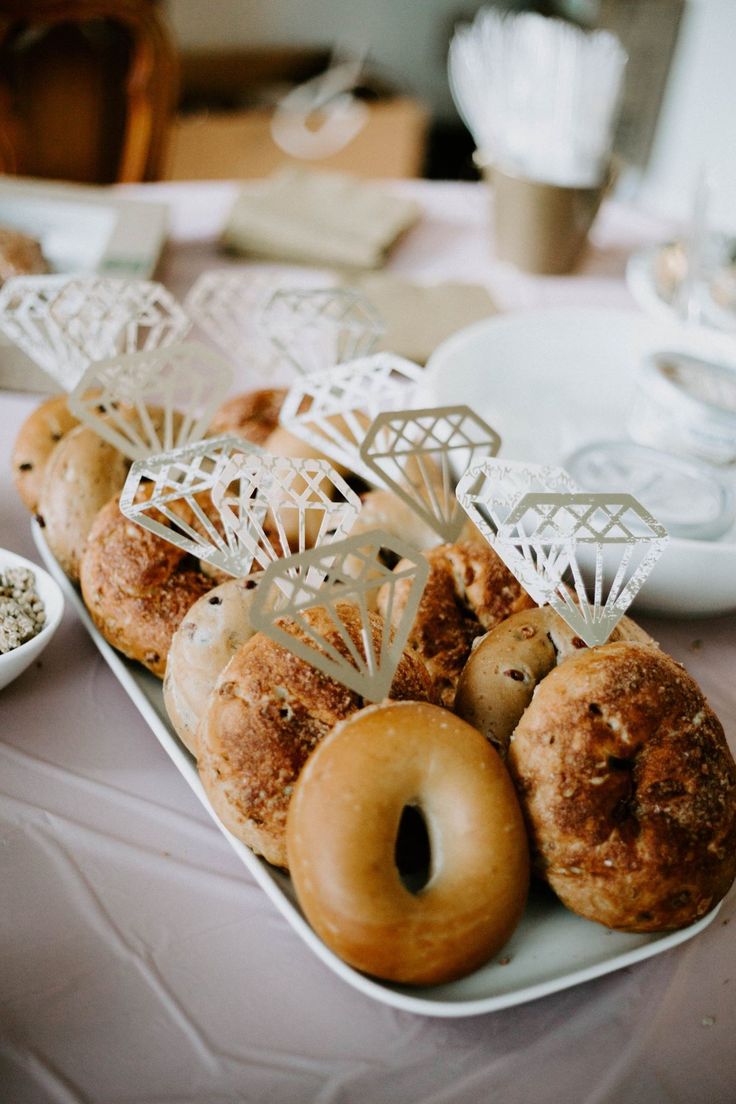 donuts and other pastries are arranged on a white platter at a wedding reception