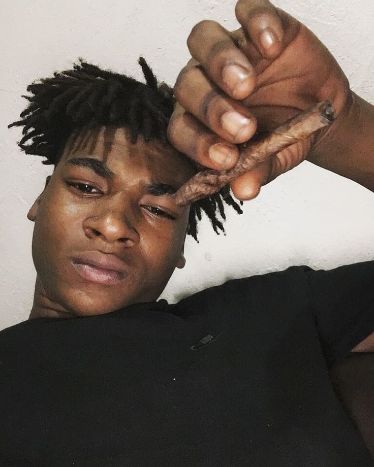 a young man with dreadlocks is getting his hair cut