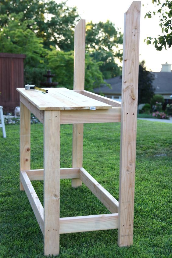 a wooden chair sitting on top of a lush green field