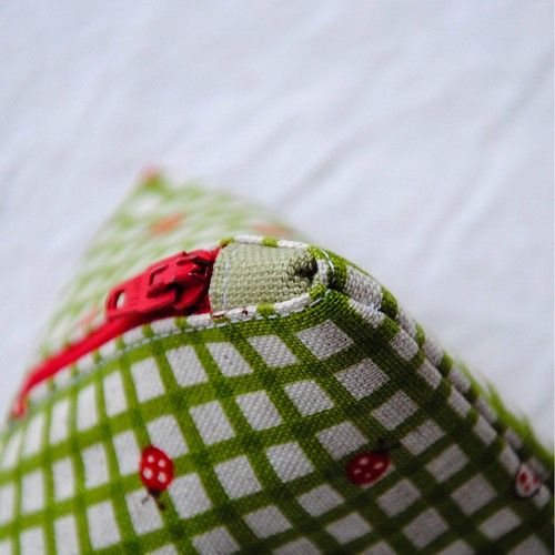 a green and white checkered fabric with red buttons on the bottom part of it