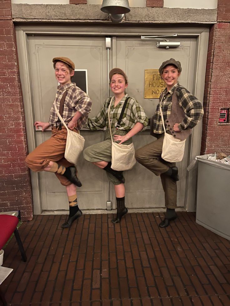 three people standing in front of a door wearing aprons