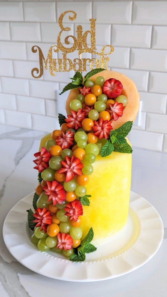 a cake decorated with fruit and leaves on a plate