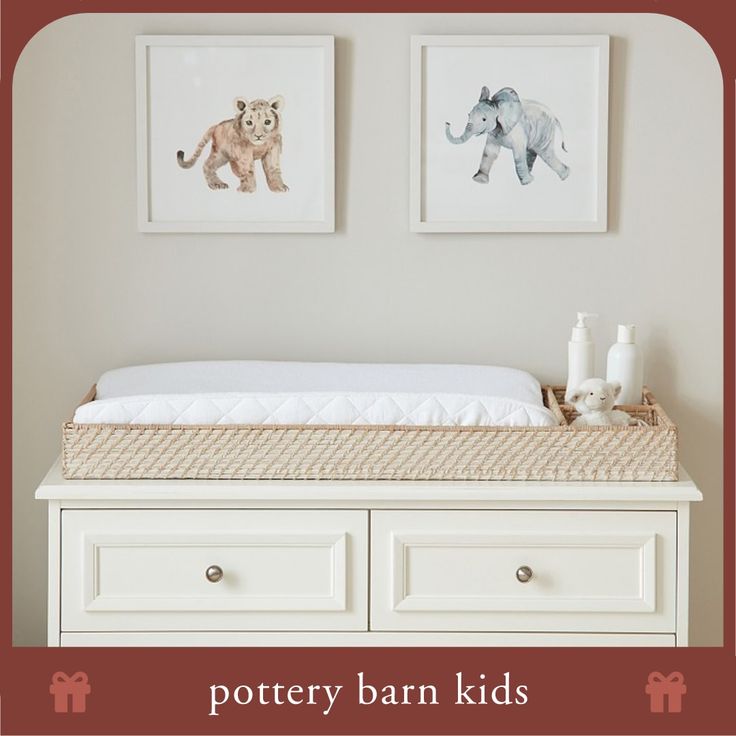 a baby crib with two pictures above it and the words pottery barn kids written below