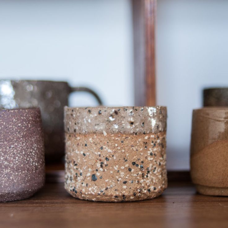 three different colored candles sitting on top of a wooden table