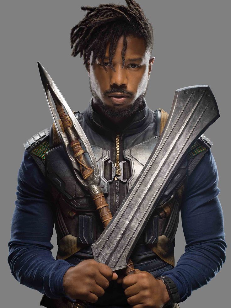 a man with dreadlocks holding two swords in his hands and looking at the camera