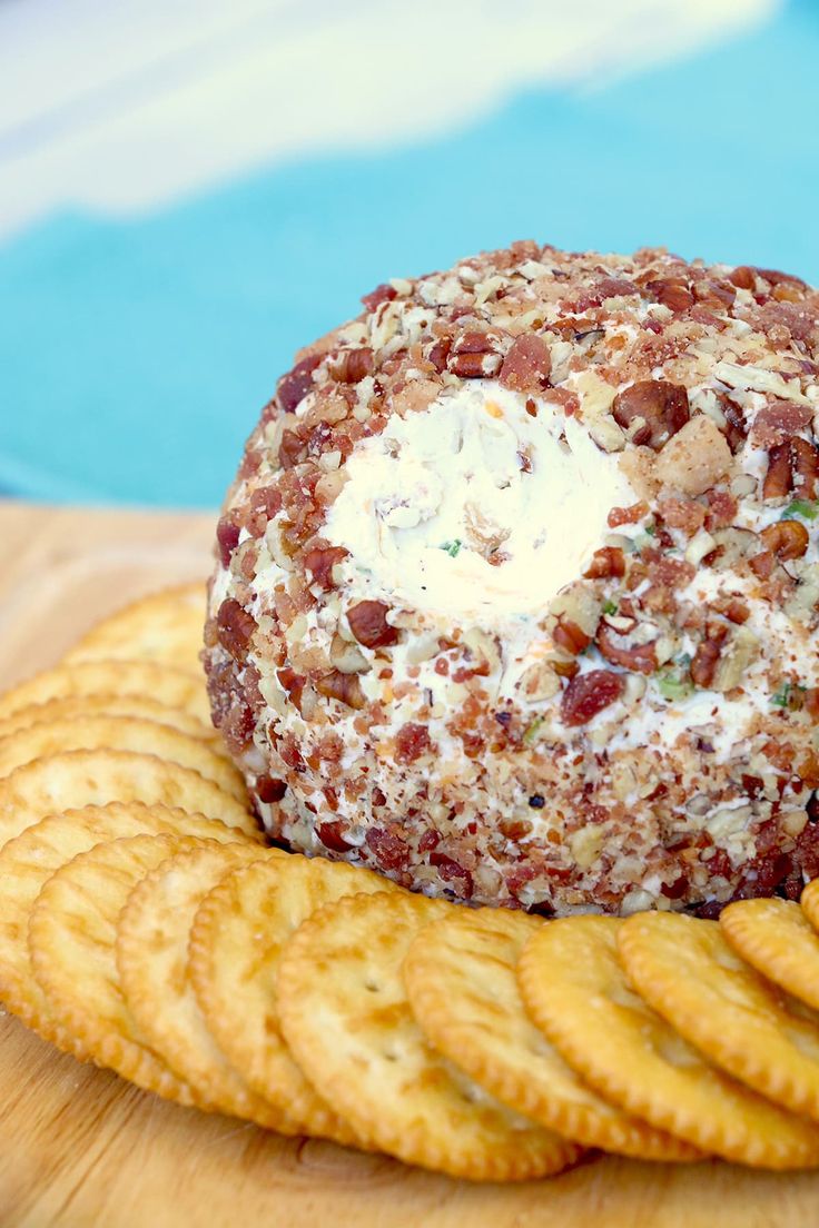 a cheese ball sitting on top of crackers next to a pool