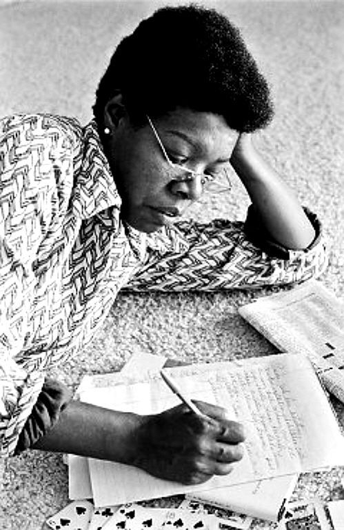 a woman sitting on the floor with her head in her hands and reading a book