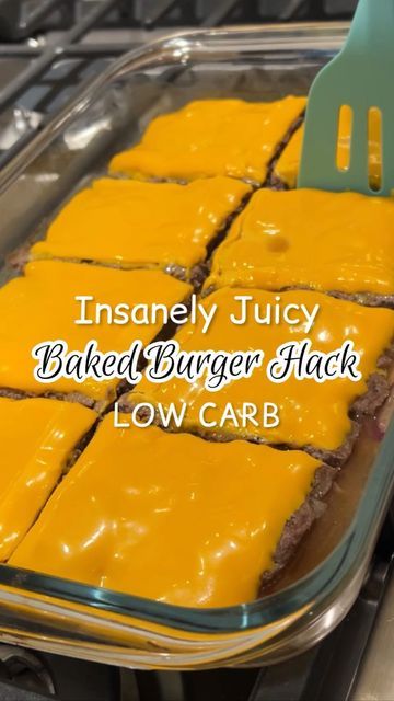 a pan filled with baked burgers and cheese on top of a stove next to a spatula