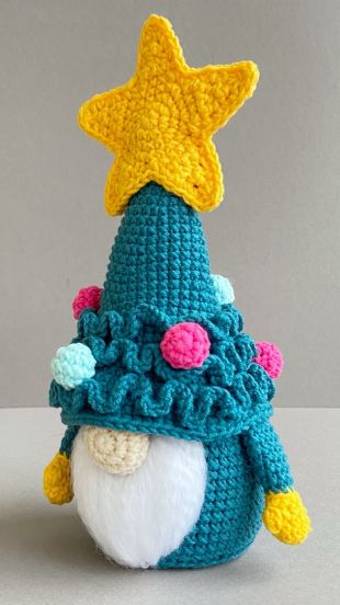 a crocheted hat with a star on top and a small stuffed animal in the middle