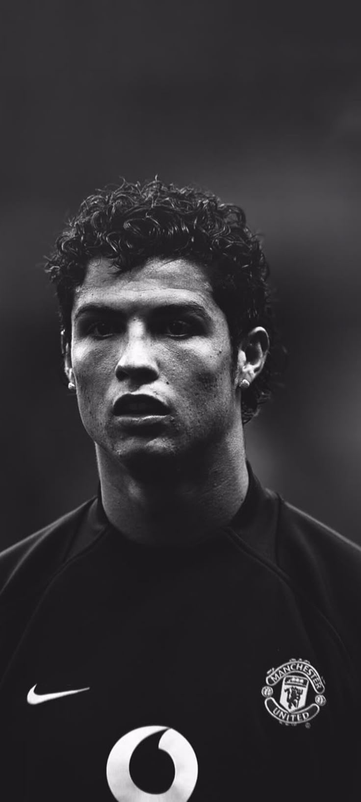 a man with curly hair wearing a black shirt