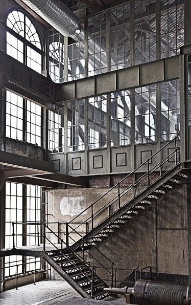 an old building with lots of windows and metal stairs leading up to the second floor