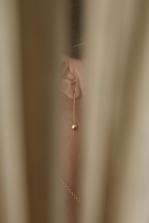 a woman's ear is seen through the curtain