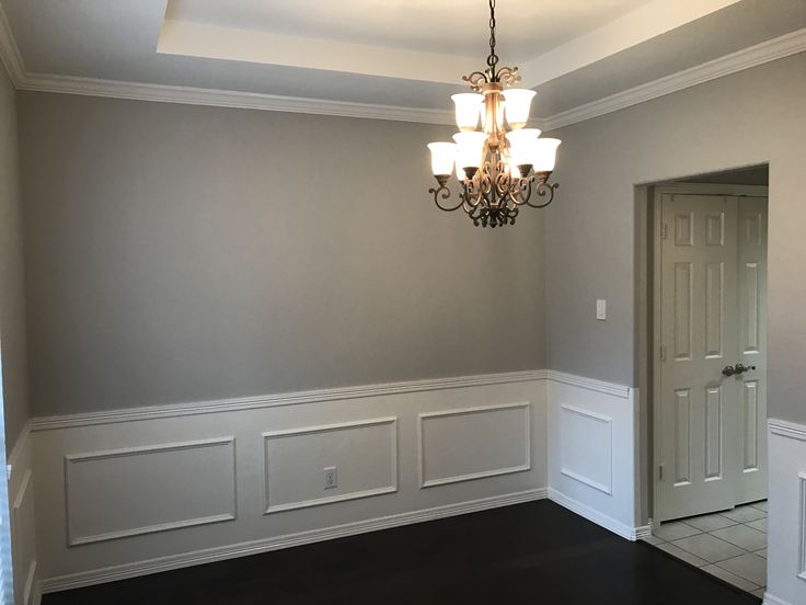 a chandelier hangs from the ceiling in an empty room