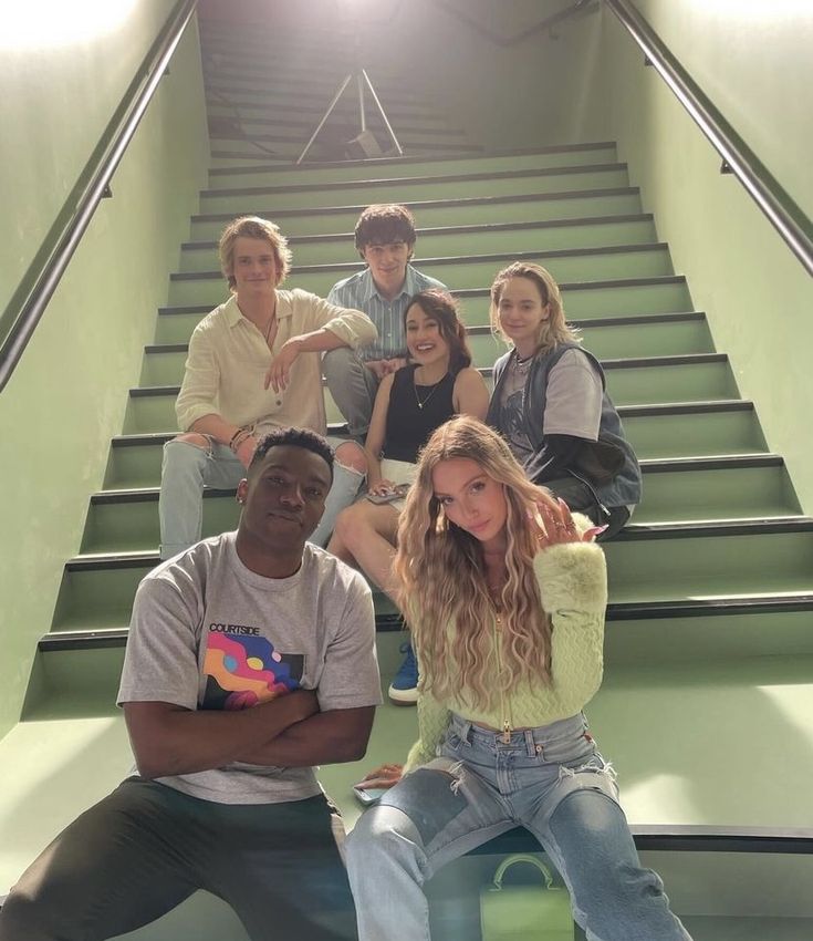 a group of young people sitting on top of stairs