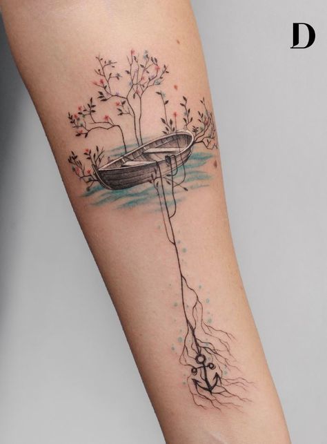 a woman's arm with a tree and boat tattoo on it