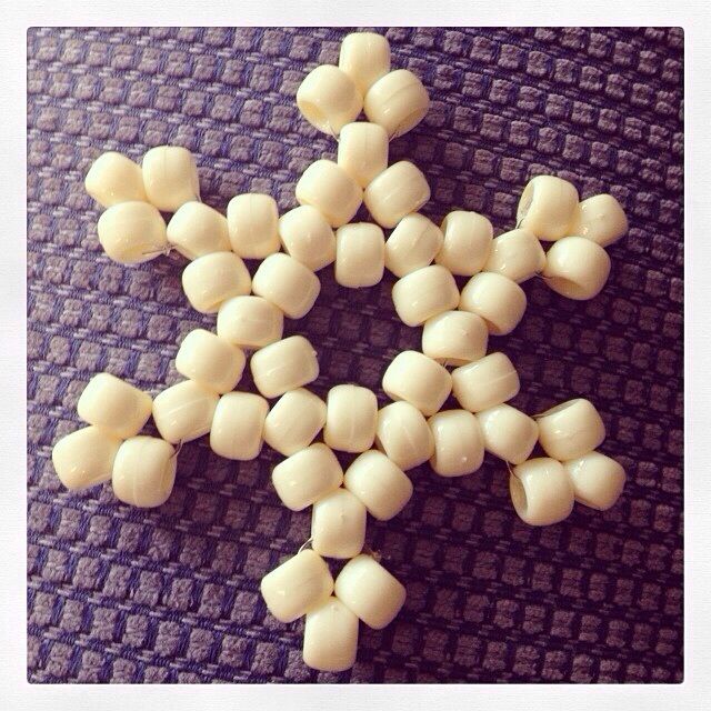 several pieces of white chocolate are arranged in the shape of a snowflake on a purple surface