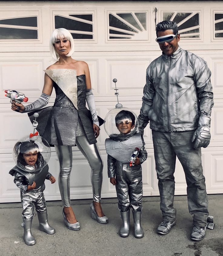 a man and two children are dressed up as astronauts in front of a garage door