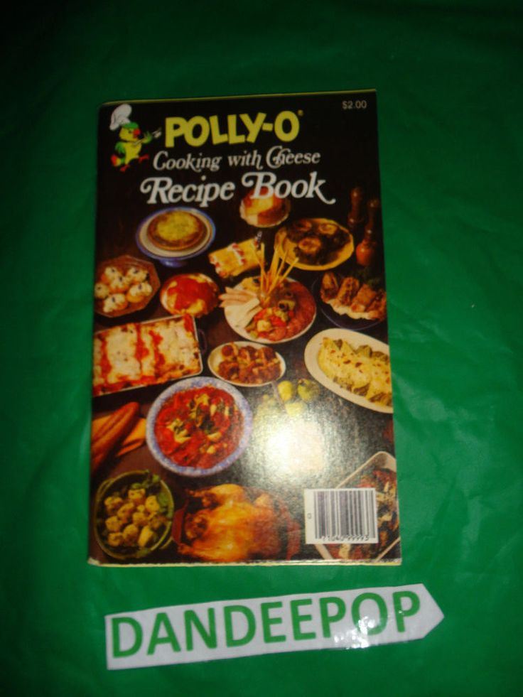 the cookbook is sitting on top of a green tablecloth that has an image of various food items in it