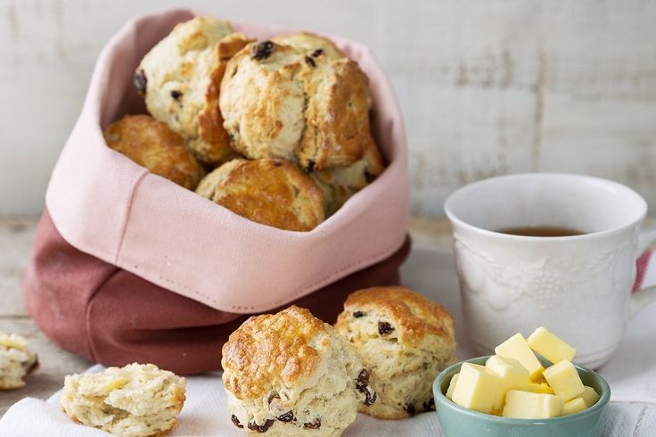 biscuits and butter are sitting next to a cup of tea