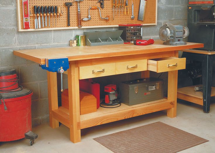 a workbench with tools hanging on the wall