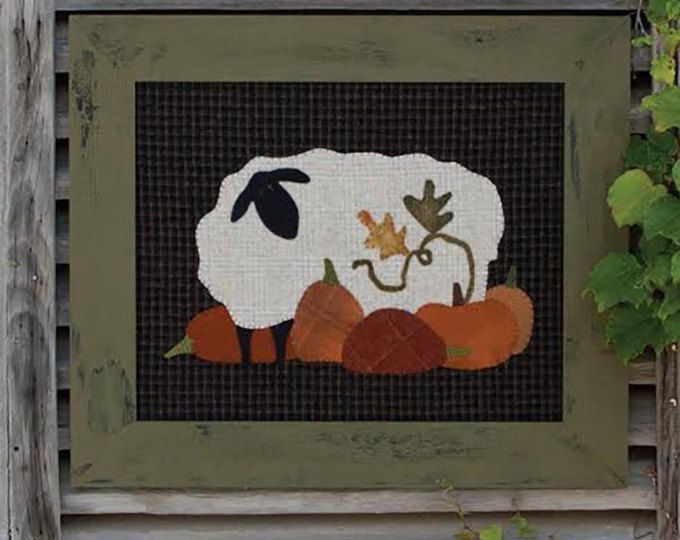 a sheep is standing in the grass with pumpkins