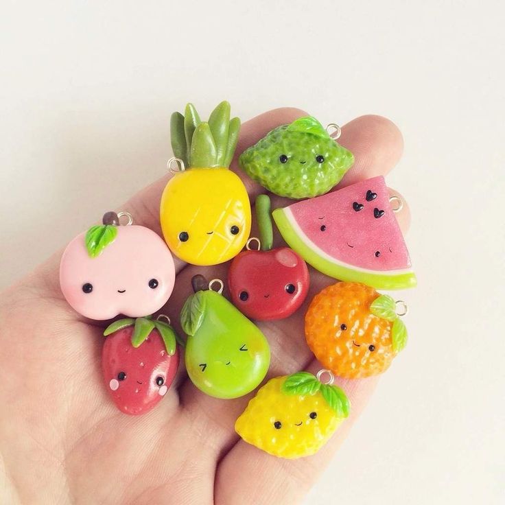 a hand holding a bunch of fruit charms