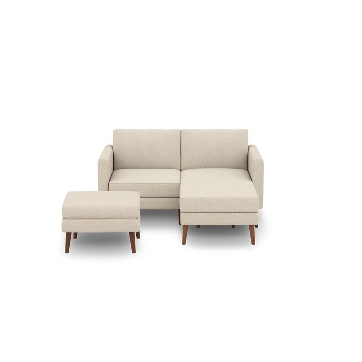 a white couch and ottoman sitting next to each other