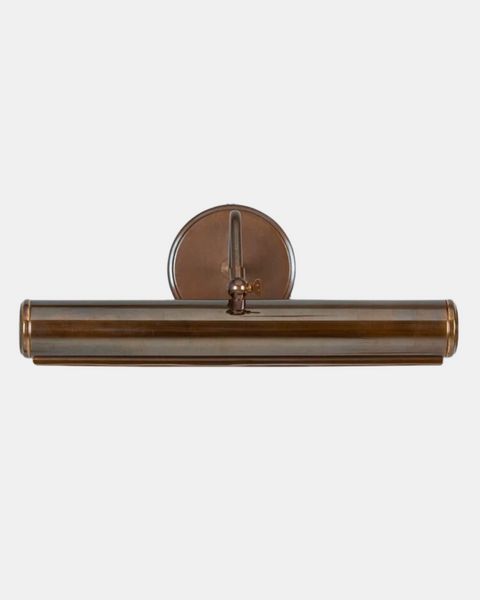 an antique brass finish bathroom light with a round glass shade on the top and bottom