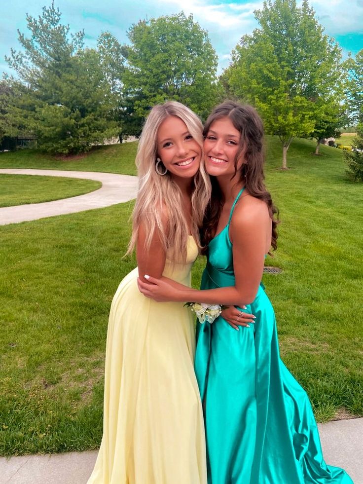 two girls in dresses standing next to each other