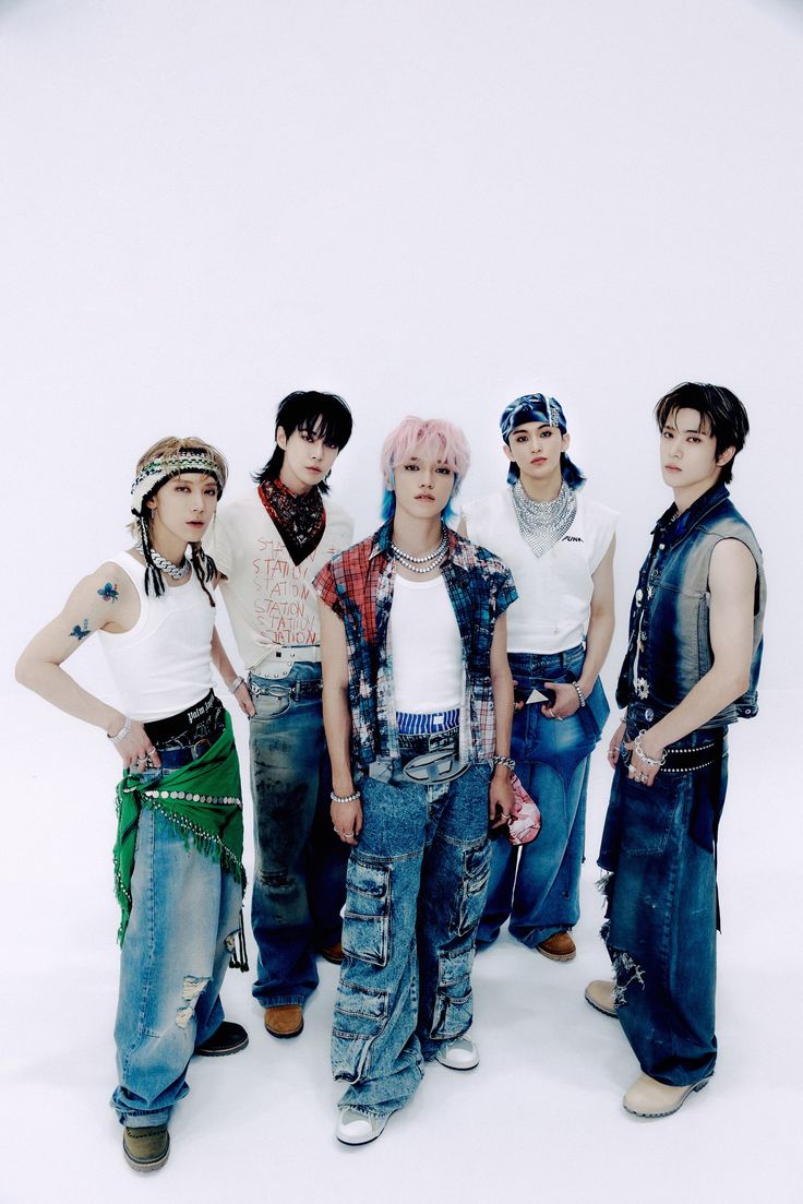 group of young men standing next to each other in front of a white background,