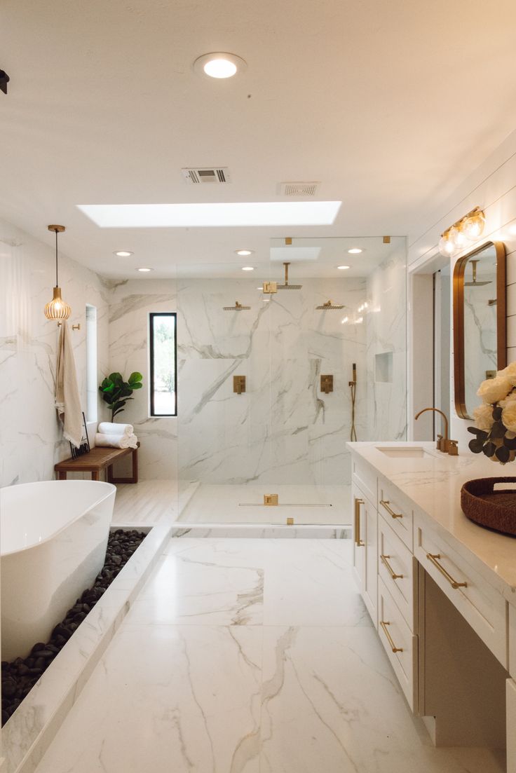 a large bathroom with white marble and gold accents