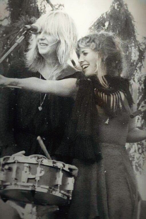 two women standing next to each other near a drum