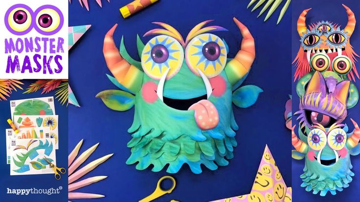 paper mache monster masks with scissors and other crafting supplies on a blue background