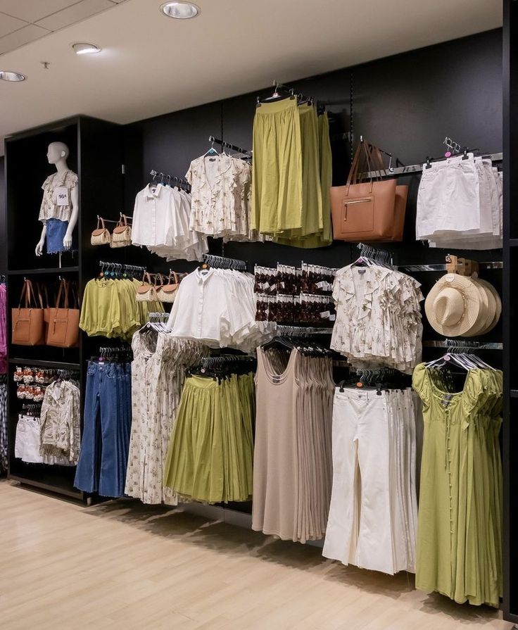 a clothing store with clothes and handbags on display